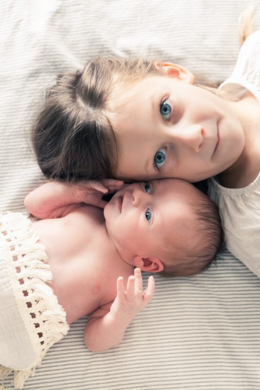 Sister and newborn side-by-side in-home photo session