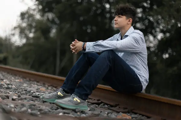 Senior Boy Grad Sitting Railroad Track Photo Idea