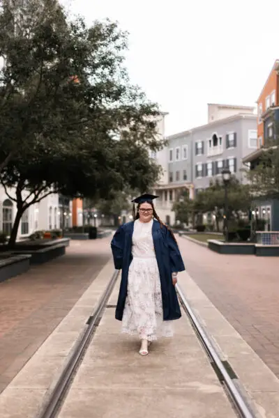 Senior Girl Graduate Walking With Cap And Gown Photo Idea