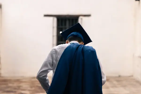 Senior Grad Adjusting Clothes Behind Back Cap And Gown Photo Idea