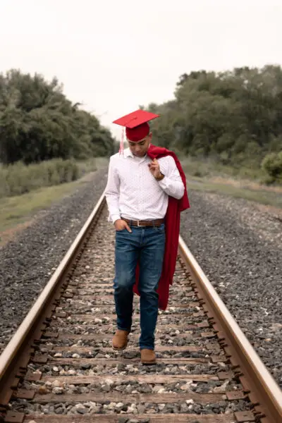 Senior Grad Walking With Cap And Gown Pose