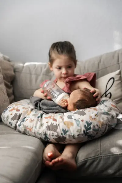 Sister Feeding Newborn Baby Brother Captured Photo